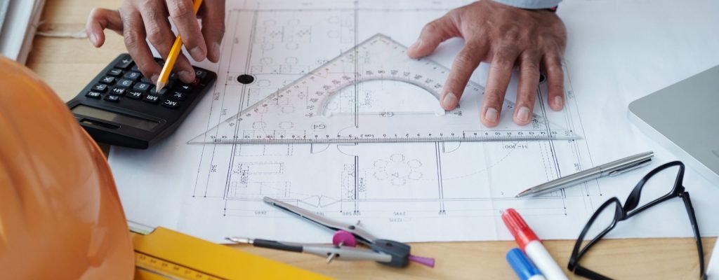 Hands of engineer checking construction plan on his table